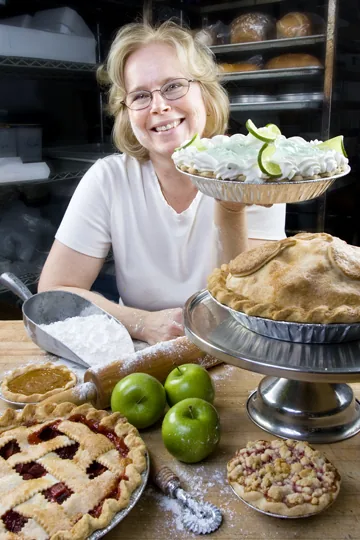 A baker lifting a freshly baked pie at the Village Bakehouse.
